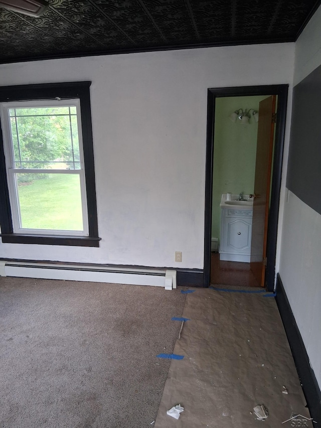 908 Lansing Ave, Jackson, MI 49202 - empty room with a baseboard heating unit, carpet, and a sink