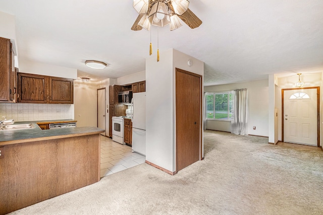 kitchen featuring white appliances, light carpet, a ceiling fan, tasteful backsplash, and a sink