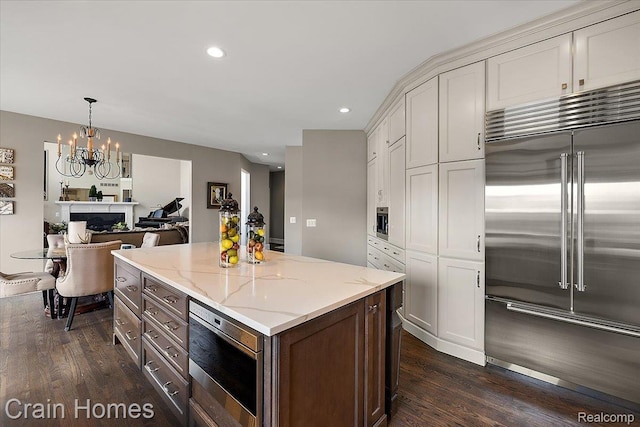 49729 Sandra Dr, Shelby Twp, MI 48315 - kitchen featuring stainless steel appliances, dark wood finished floors, a chandelier, light stone counters, and recessed lighting