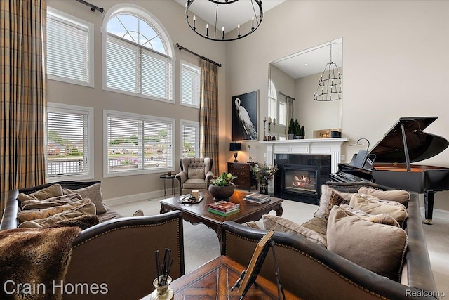 49729 Sandra Dr, Shelby Twp, MI 48315 - living area featuring a high ceiling, baseboards, plenty of natural light, a tiled fireplace, and a chandelier