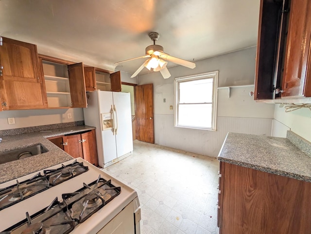 24573 Stewart Ave, Warren, MI 48089 - kitchen with white appliances, a wainscoted wall, light floors, brown cabinets, and a ceiling fan