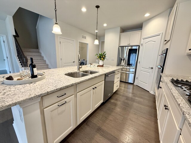 2763 Polson St, Ann Arbor, MI 48105 - kitchen featuring appliances with stainless steel finishes, a sink, white cabinets, dark wood-style flooring, and light stone counters