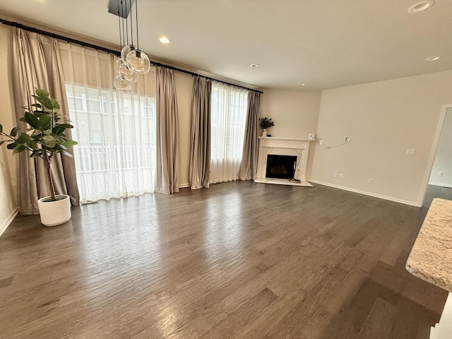 2763 Polson St, Ann Arbor, MI 48105 - unfurnished living room featuring dark wood-type flooring, baseboards, a premium fireplace, and recessed lighting