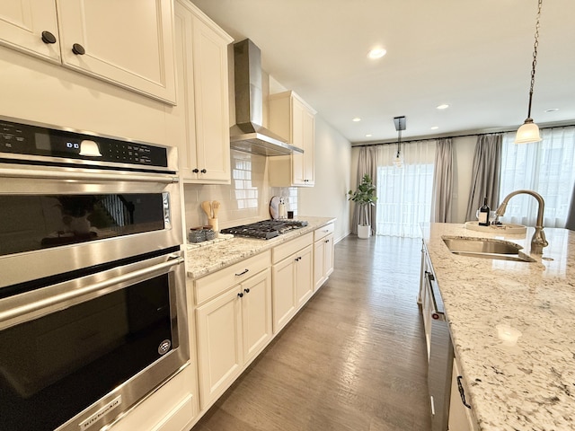 2763 Polson St, Ann Arbor, MI 48105 - kitchen with wall chimney exhaust hood, stainless steel appliances, a sink, wood finished floors, and recessed lighting