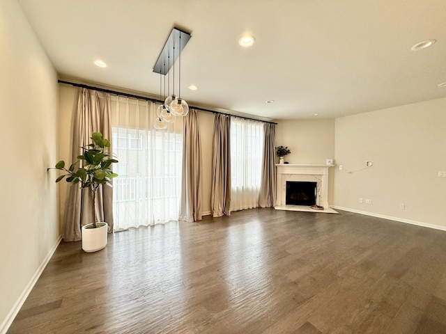 2763 Polson St, Ann Arbor, MI 48105 - unfurnished living room with dark wood-type flooring, a fireplace, baseboards, and recessed lighting