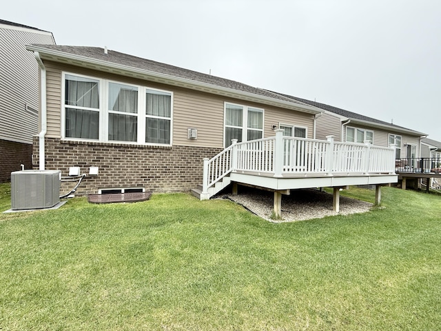 2763 Polson St, Ann Arbor, MI 48105 - back of house with central AC unit, a wooden deck, brick siding, and a lawn