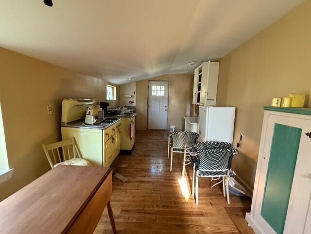 7224 County Farm Rd, Lexington, MI 48450 - kitchen with wood finished floors, vaulted ceiling, gas stove, white cabinets, and dark countertops