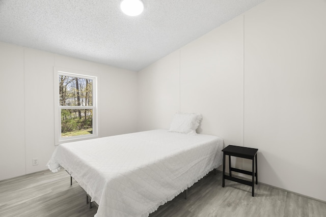 2906 Frankfort Hwy, Frankfort, MI 49635 - bedroom featuring wood finished floors and a textured ceiling
