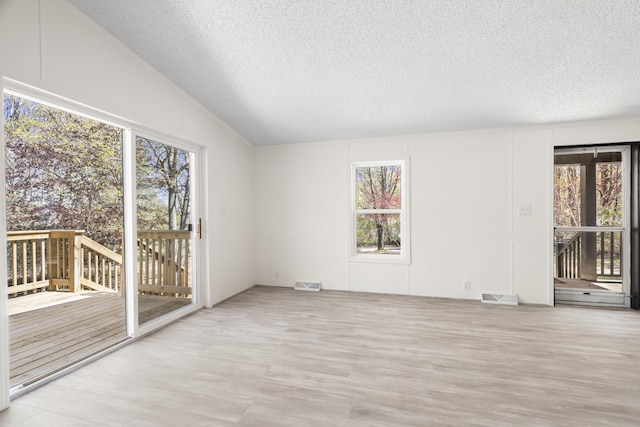 2906 Frankfort Hwy, Frankfort, MI 49635 - spare room with healthy amount of natural light, a textured ceiling, and lofted ceiling