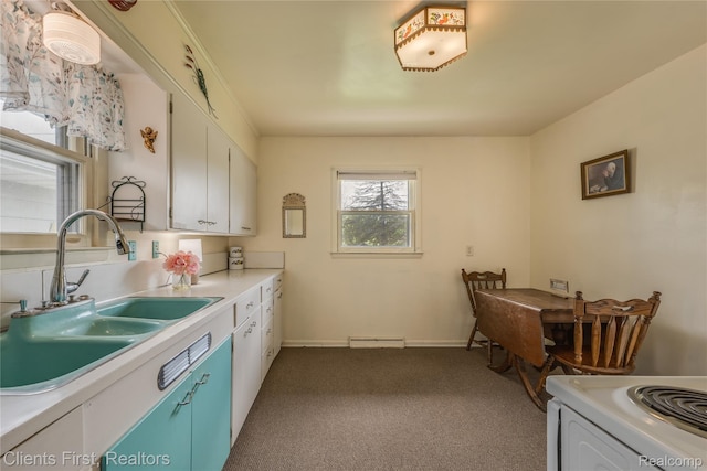 631 Lindsay St, West Branch, MI 48661 - kitchen featuring a sink, dark colored carpet, light countertops, white cabinetry, and blue cabinetry