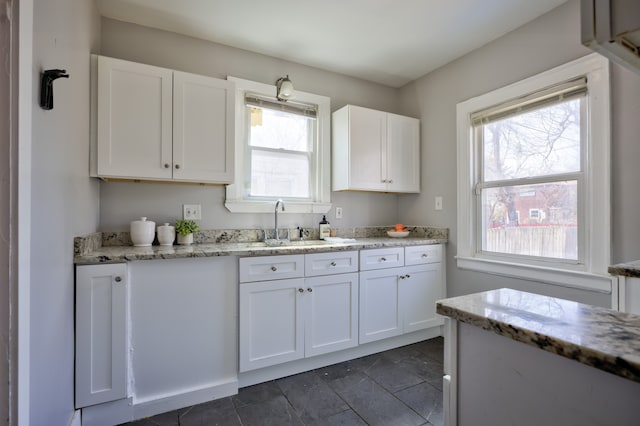 14955 Penrod St, Detroit, MI 48223 - kitchen featuring a sink, white cabinets, plenty of natural light, and light stone countertops