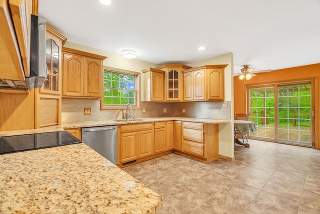 kitchen with dishwasher, decorative backsplash, a sink, light stone countertops, and glass insert cabinets