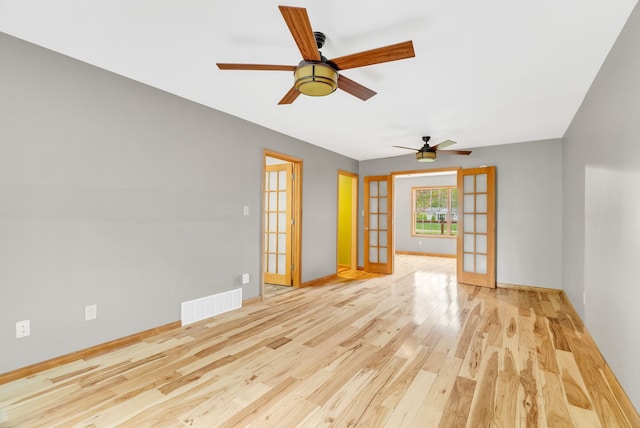 unfurnished room featuring french doors, a ceiling fan, wood finished floors, and baseboards