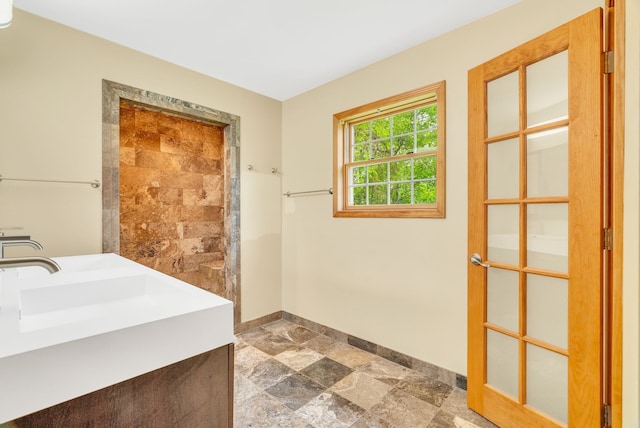 bathroom with stone finish flooring and baseboards