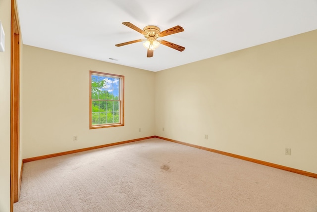 unfurnished room featuring baseboards, light colored carpet, and a ceiling fan