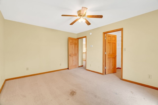 unfurnished bedroom with light colored carpet, baseboards, and ceiling fan