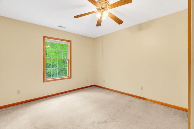 unfurnished room with light colored carpet, baseboards, and ceiling fan