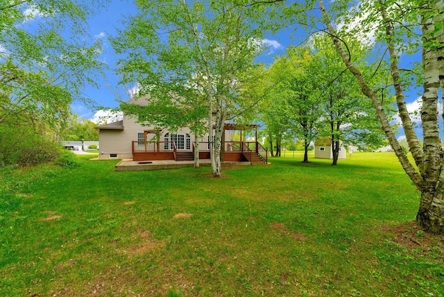 view of grassy yard featuring a wooden deck
