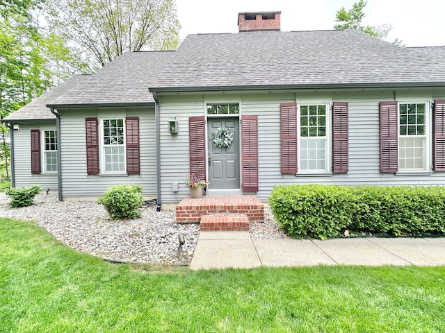 4909 Barnstable Ln, Lansing, MI 48906 - new england style home featuring a chimney, roof with shingles, and a front lawn