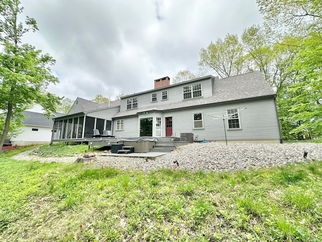 4909 Barnstable Ln, Lansing, MI 48906 - back of house featuring a sunroom, a chimney, a hot tub, and a shingled roof