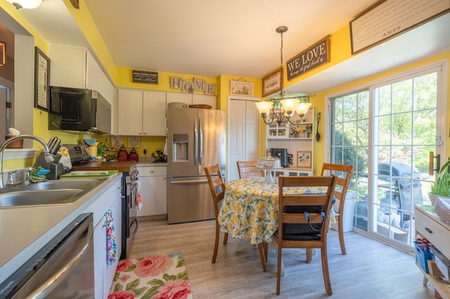 3897 Hunters Way, Canton, MI 48188 - kitchen with appliances with stainless steel finishes, a chandelier, light wood-type flooring, a sink, and pendant lighting