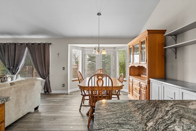 47697 Barclay Ct, Shelby Twp, MI 48317 - dining area with a chandelier, wood finished floors, baseboards, and vaulted ceiling