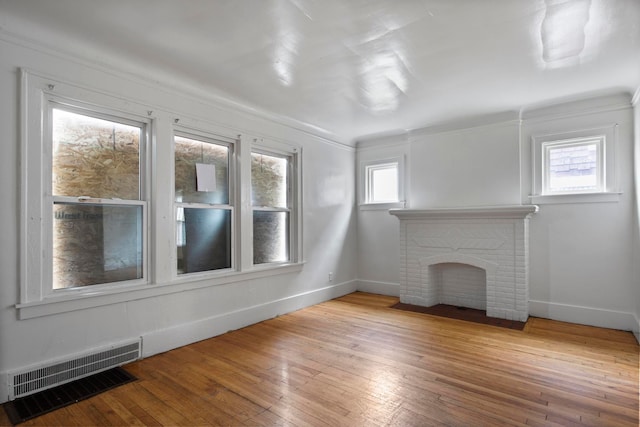 8916 Mendota St, Detroit, MI 48204 - unfurnished living room with baseboards, wood-type flooring, plenty of natural light, a fireplace, and ornamental molding