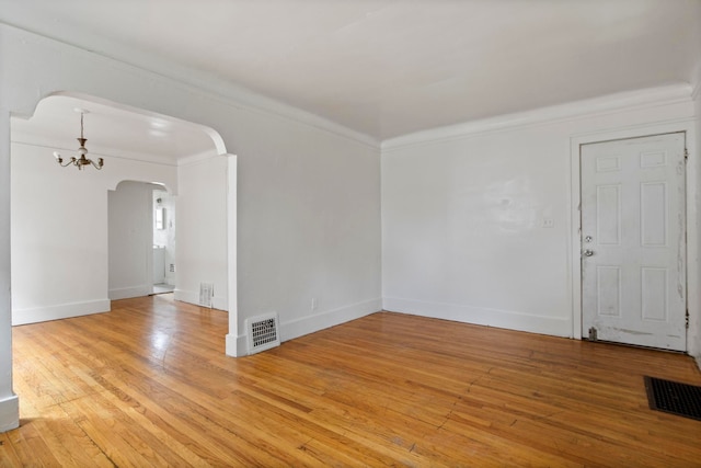 8916 Mendota St, Detroit, MI 48204 - unfurnished room featuring arched walkways, light wood-style floors, crown molding, a chandelier, and baseboards