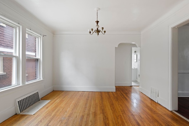 8916 Mendota St, Detroit, MI 48204 - empty room with arched walkways, a chandelier, plenty of natural light, and radiator heating unit