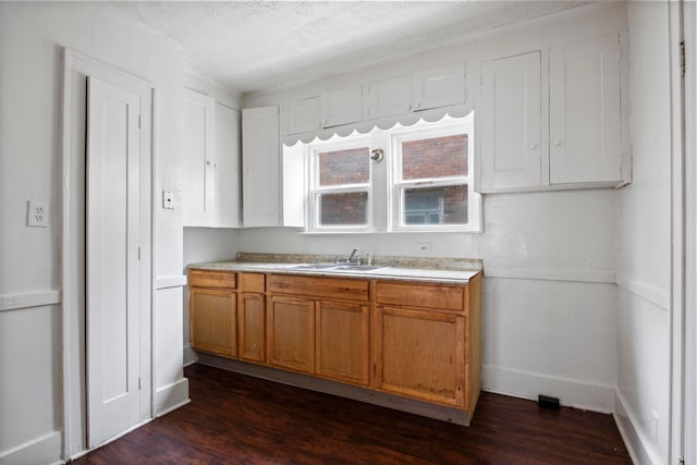 8916 Mendota St, Detroit, MI 48204 - kitchen featuring a sink, dark wood-type flooring, light countertops, brown cabinetry, and baseboards