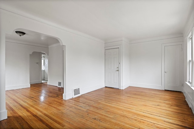 8916 Mendota St, Detroit, MI 48204 - spare room featuring arched walkways, light wood-type flooring, and baseboards