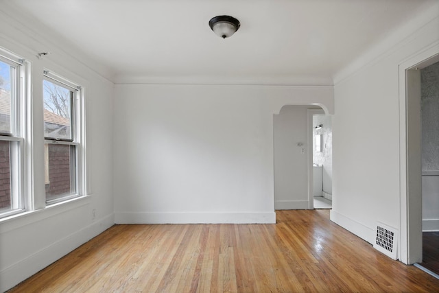 8916 Mendota St, Detroit, MI 48204 - unfurnished room featuring arched walkways, light wood-type flooring, and baseboards