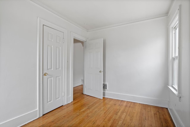 8916 Mendota St, Detroit, MI 48204 - unfurnished bedroom featuring light wood-type flooring, crown molding, and baseboards