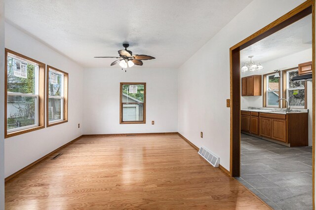 214 S Monroe St, Sturgis, MI 49091 - unfurnished room featuring healthy amount of natural light, ceiling fan, light wood finished floors, and a chandelier