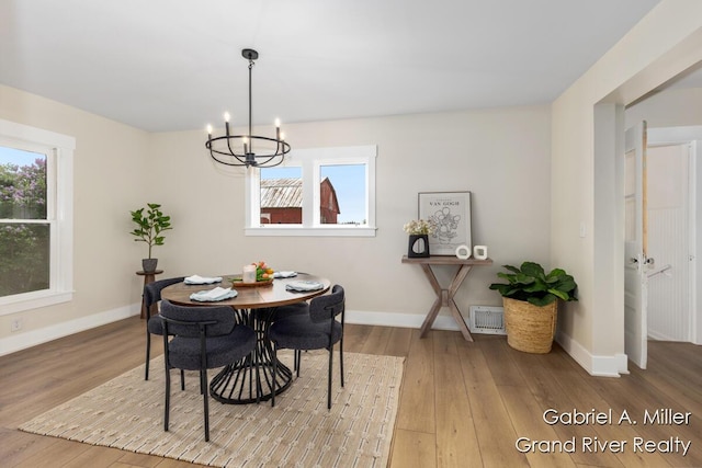 49 E 112th St, Grant, MI 49327 - dining area with a chandelier, hardwood / wood-style flooring, plenty of natural light, and baseboards