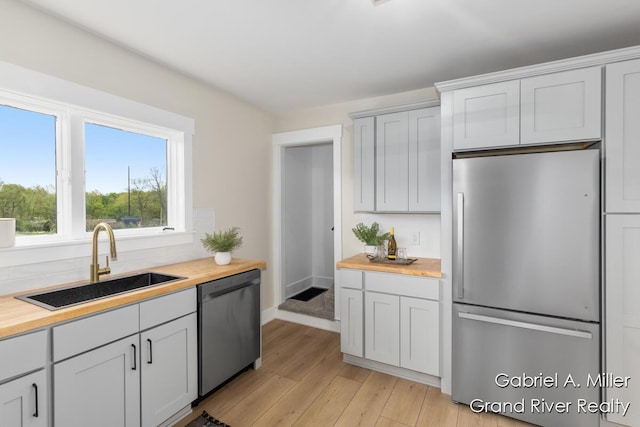 49 E 112th St, Grant, MI 49327 - kitchen with stainless steel appliances, butcher block countertops, and a sink