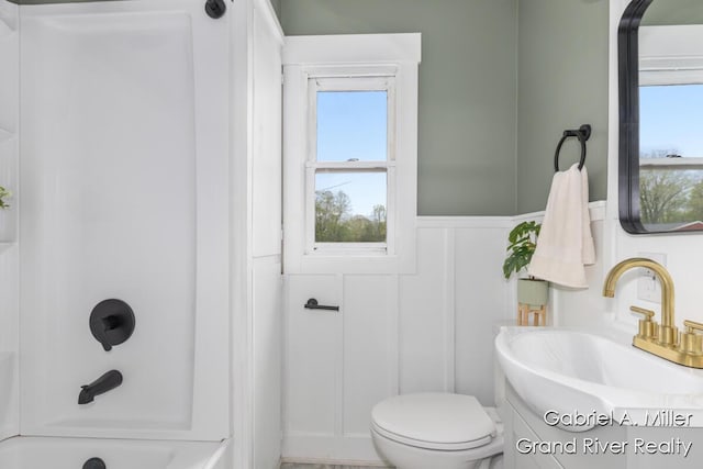 49 E 112th St, Grant, MI 49327 - full bathroom with toilet, vanity, wainscoting, a decorative wall, and bathing tub / shower combination