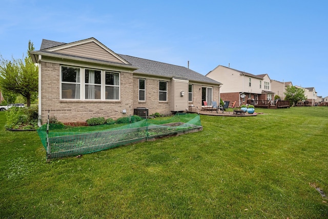 47291 Fairlawn Ct, Canton, MI 48188 - back of house featuring brick siding, a garden, cooling unit, and a yard