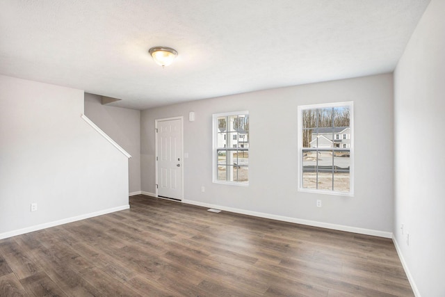 7987 Sierra Dr, Belding, MI 48809 - entryway featuring dark wood-style floors, baseboards, and stairs