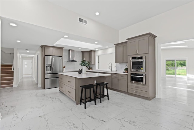 49712 Geddes Rd, Canton, MI 48188 - kitchen featuring appliances with stainless steel finishes, wall chimney exhaust hood, a sink, decorative backsplash, and light countertops