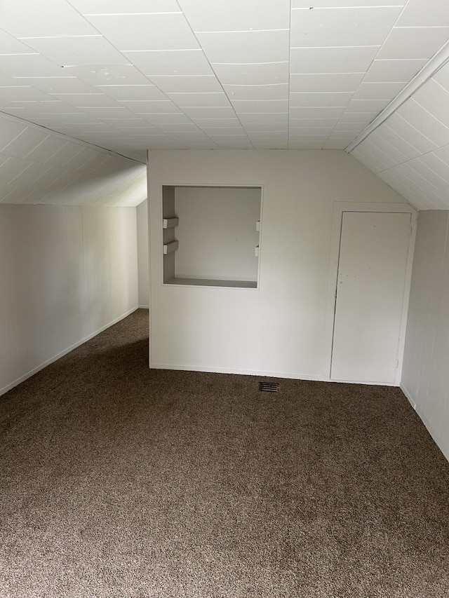 additional living space with carpet flooring and vaulted ceiling