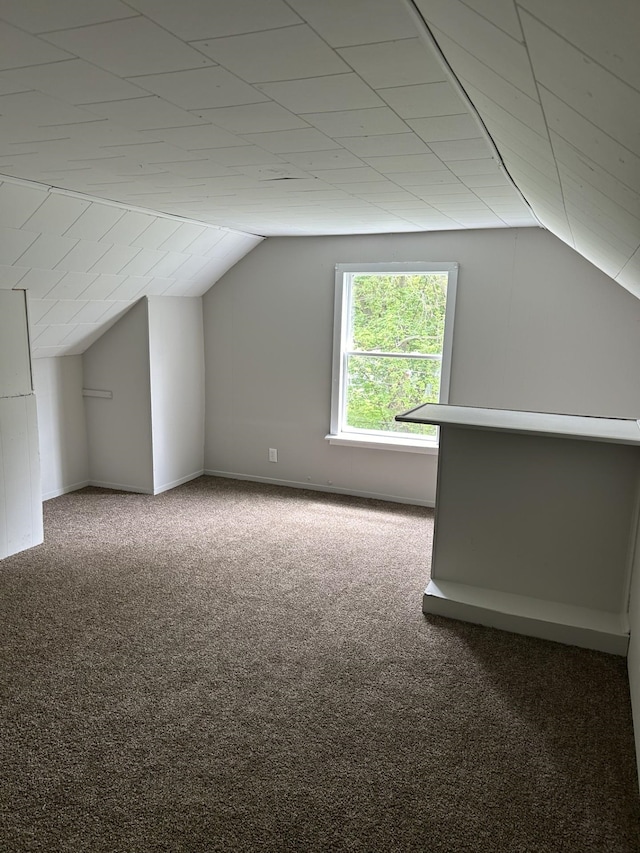 additional living space featuring carpet flooring, vaulted ceiling, and baseboards