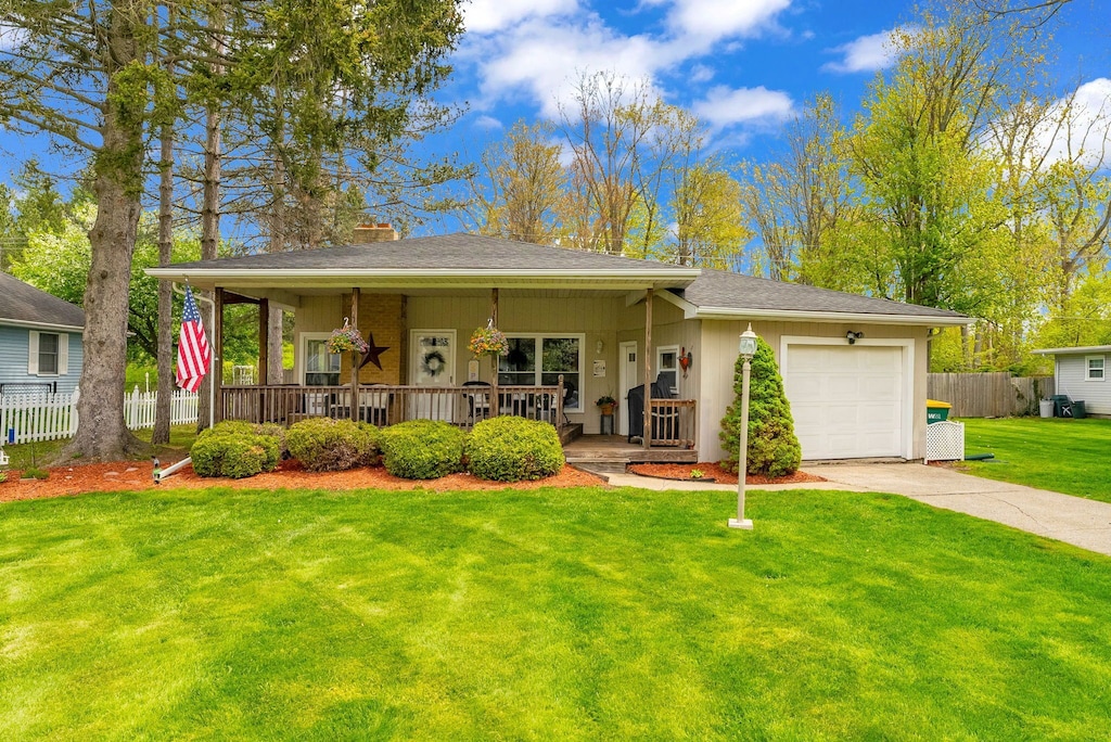 2510 Brownwood Dr, Port Huron, MI 48060 - view of front of property featuring driveway, a porch, an attached garage, roof with shingles, and a chimney