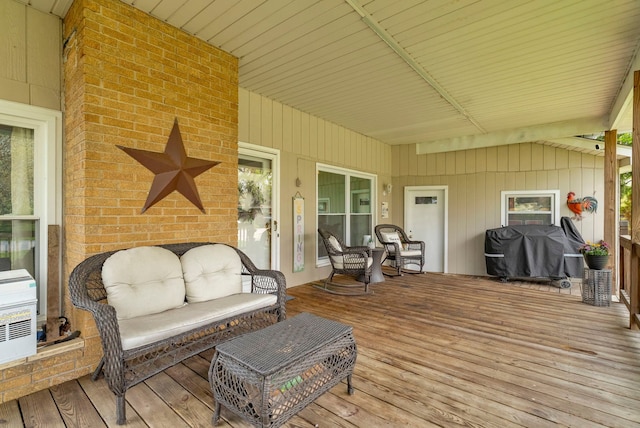 wooden terrace with area for grilling and an outdoor hangout area