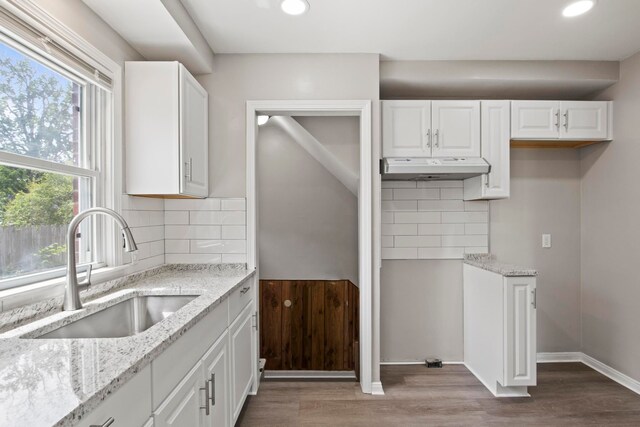8105 Bramell, Redford, MI 48239 - kitchen with a sink, light stone counters, under cabinet range hood, white cabinets, and wood finished floors