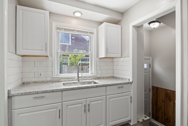 8105 Bramell, Redford, MI 48239 - kitchen featuring a sink, white cabinetry, a wainscoted wall, light stone countertops, and tasteful backsplash