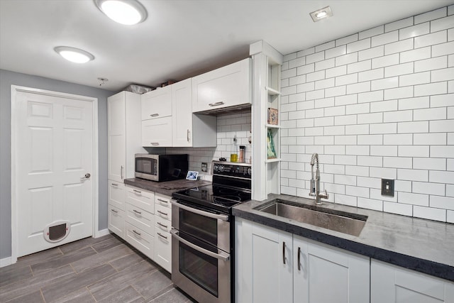 1812 Orchard St, Ann Arbor, MI 48103 - kitchen with stainless steel appliances, a sink, backsplash, dark countertops, and white cabinetry