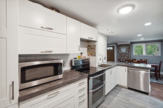 1812 Orchard St, Ann Arbor, MI 48103 - kitchen with stainless steel appliances, a sink, tasteful backsplash, white cabinets, and recessed lighting