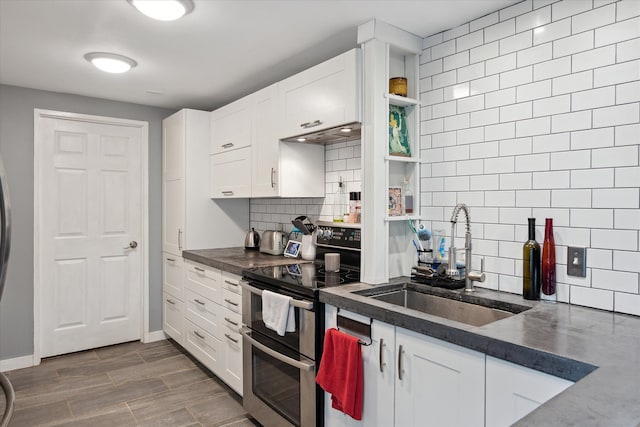 1812 Orchard St, Ann Arbor, MI 48103 - kitchen featuring double oven range, a sink, dark countertops, white cabinetry, and decorative backsplash
