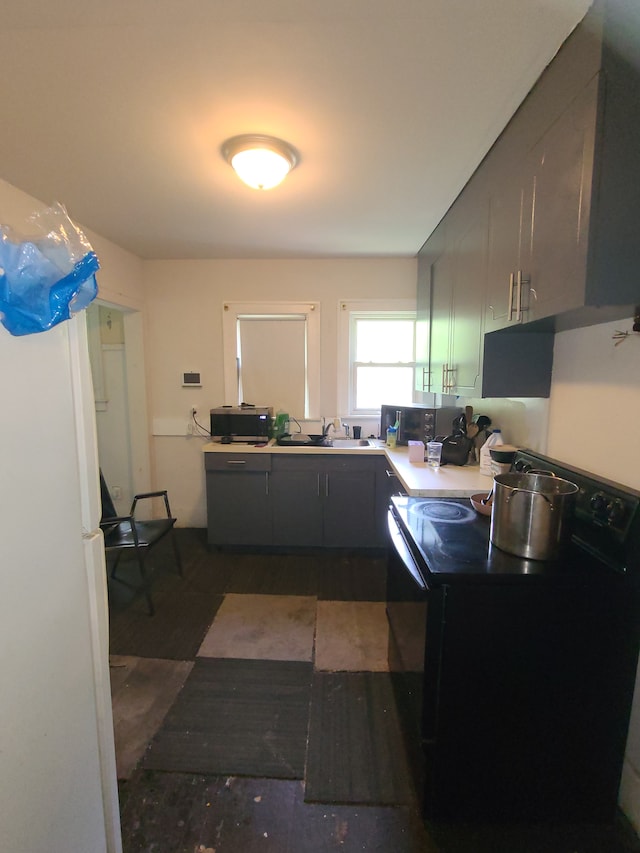 1814 Jasmine Ave, Flint, MI 48503 - kitchen with black range with electric stovetop, dark wood-style flooring, a sink, and light countertops